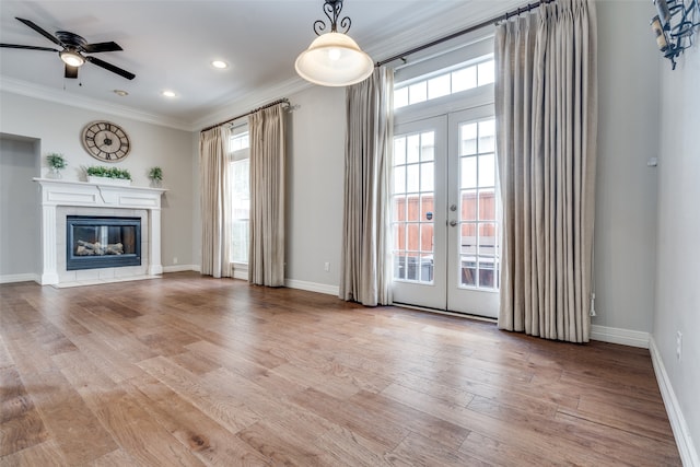 unfurnished living room featuring a tile fireplace, french doors, and light hardwood / wood-style flooring