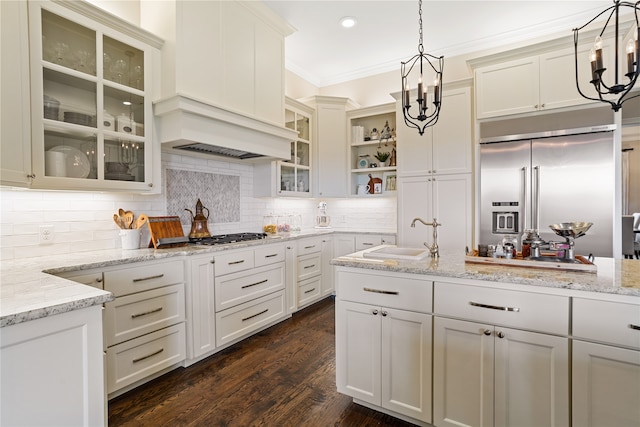 kitchen featuring pendant lighting, a chandelier, appliances with stainless steel finishes, and light stone counters