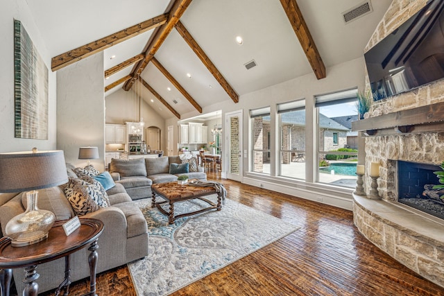 living room with a fireplace, beam ceiling, and dark hardwood / wood-style flooring