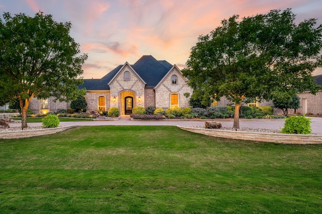 french provincial home featuring a yard