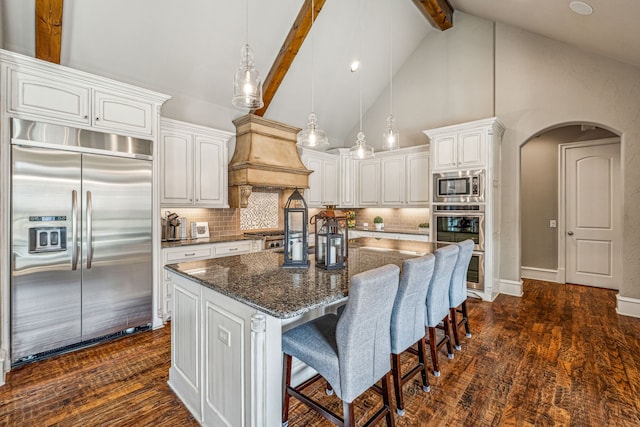 kitchen with beam ceiling, white cabinetry, high vaulted ceiling, backsplash, and built in appliances