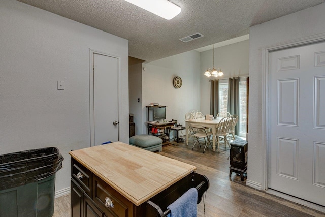 613 Purple Sage Trl, Mesquite, TX 75149 - kitchen featuring a chandelier, wood finished floors, a textured ceiling, butcher block countertops, and decorative light fixtures