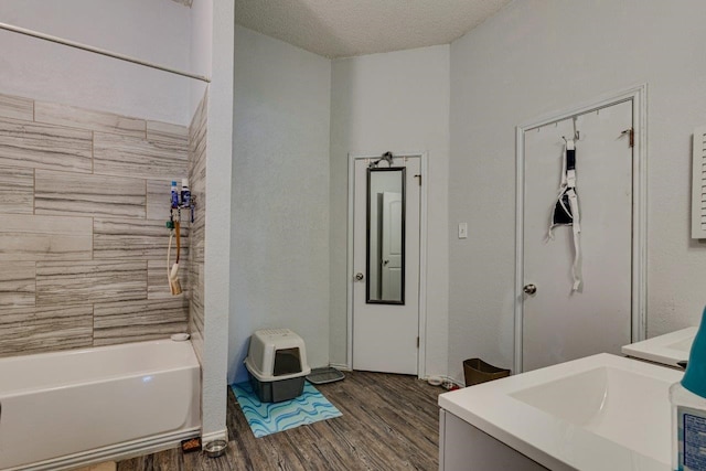 bathroom with vanity, tiled shower / bath, a textured ceiling, and hardwood / wood-style flooring