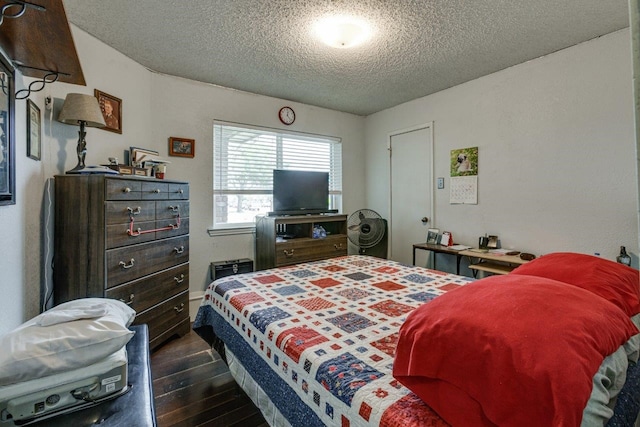 bedroom with a textured ceiling and dark hardwood / wood-style flooring