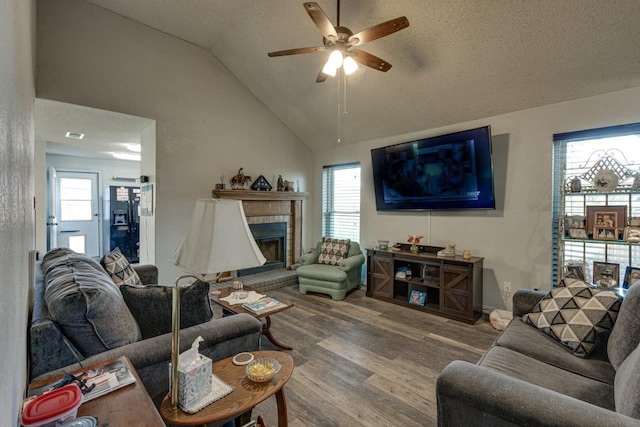 613 Purple Sage Trl, Mesquite, TX 75149 - living area featuring vaulted ceiling, ceiling fan, wood finished floors, a brick fireplace, and plenty of natural light