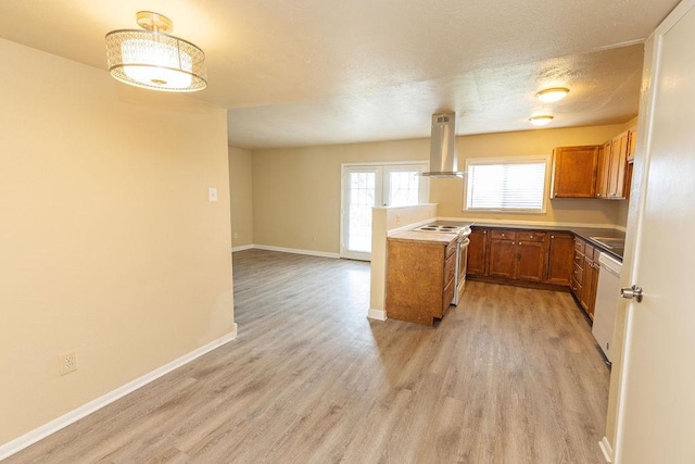 kitchen featuring a textured ceiling, white appliances, light hardwood / wood-style floors, and range hood