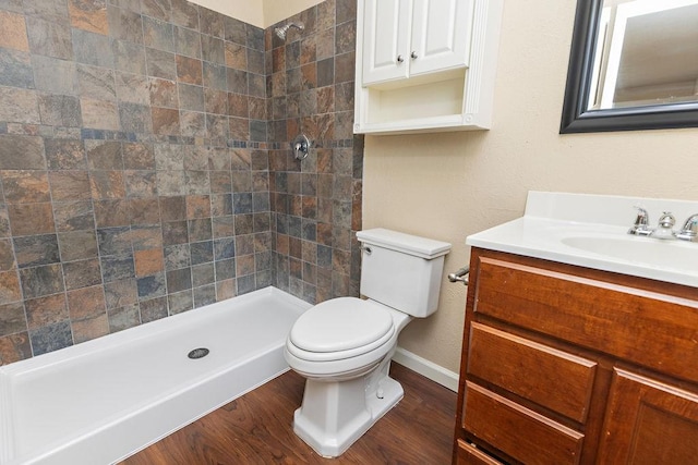 bathroom with walk in shower, hardwood / wood-style flooring, vanity, and toilet