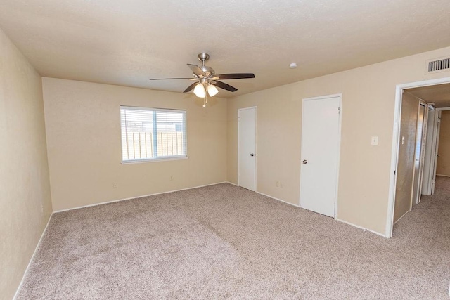 spare room featuring ceiling fan and light colored carpet