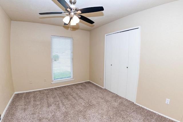 unfurnished bedroom featuring ceiling fan, a closet, and light carpet