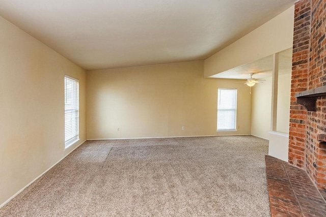 unfurnished living room featuring carpet flooring, a brick fireplace, and ceiling fan