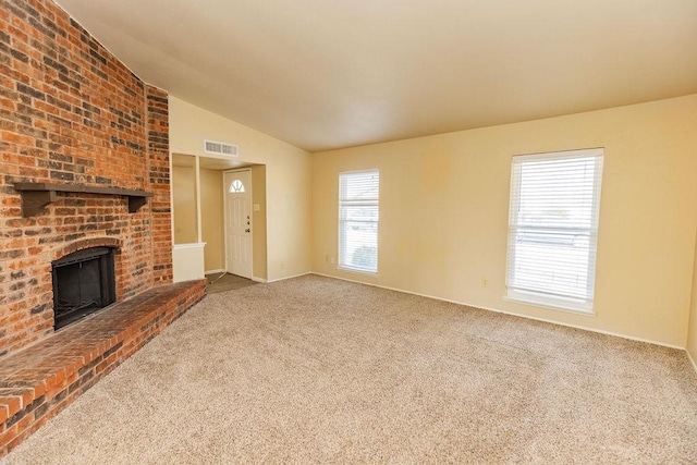 unfurnished living room featuring carpet flooring, a fireplace, and lofted ceiling