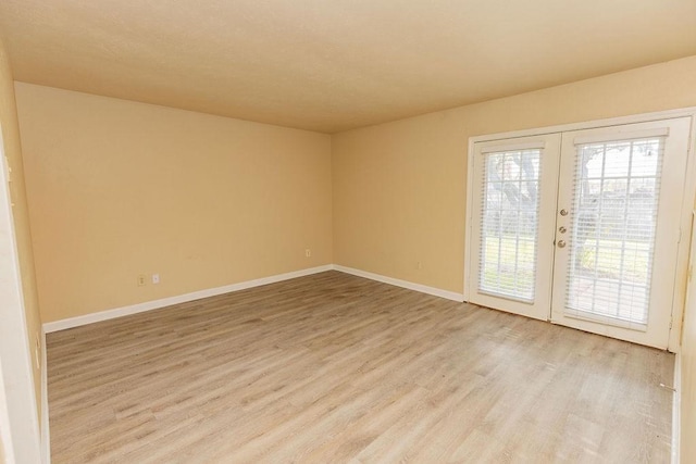 unfurnished room with light wood-type flooring and french doors