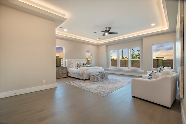 bedroom featuring ceiling fan, a raised ceiling, and hardwood / wood-style flooring