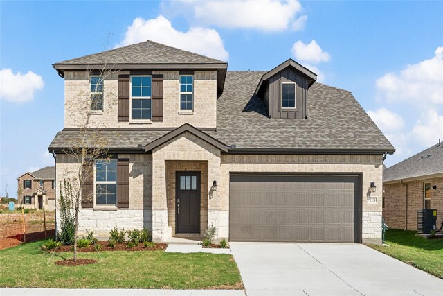 view of front of house featuring cooling unit, a garage, and a front lawn