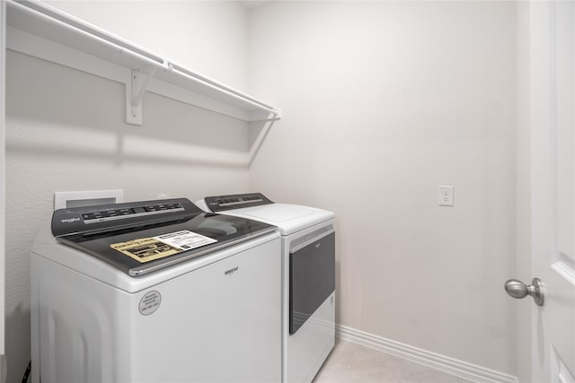 clothes washing area featuring separate washer and dryer and light tile patterned floors