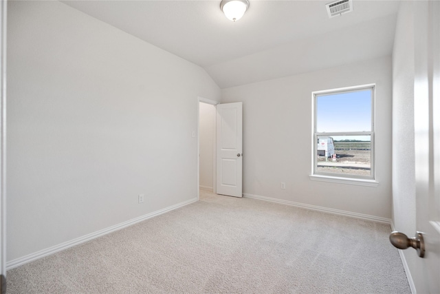 carpeted empty room with lofted ceiling