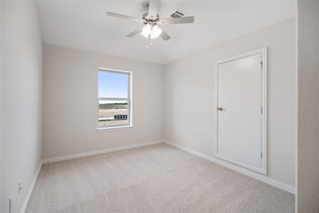 spare room featuring light carpet and ceiling fan