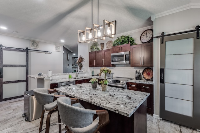 kitchen featuring a center island, a barn door, sink, and appliances with stainless steel finishes