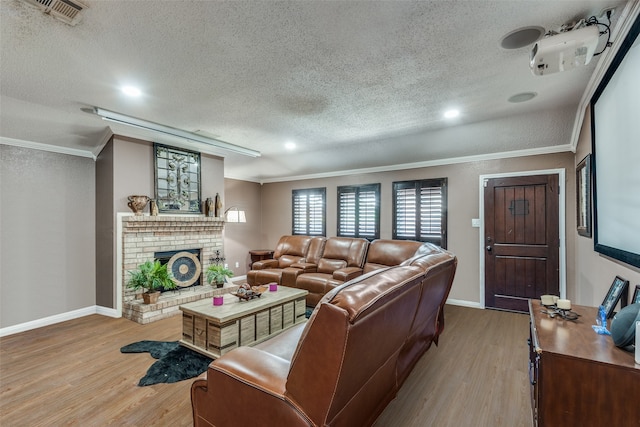 living room featuring crown molding, a textured ceiling, and light wood-type flooring