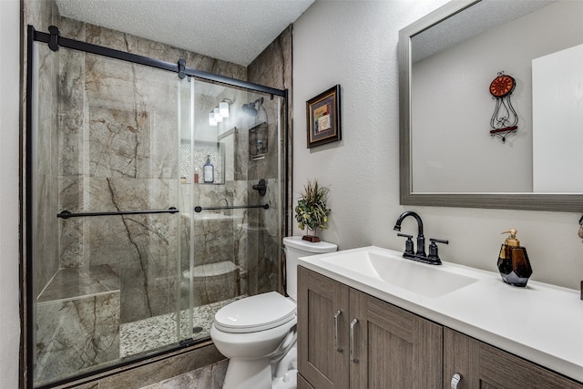 bathroom featuring walk in shower, vanity, a textured ceiling, and toilet