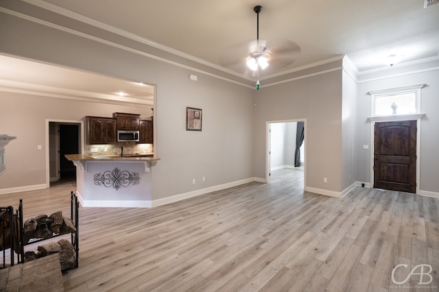 living room featuring crown molding, light hardwood / wood-style floors, and ceiling fan