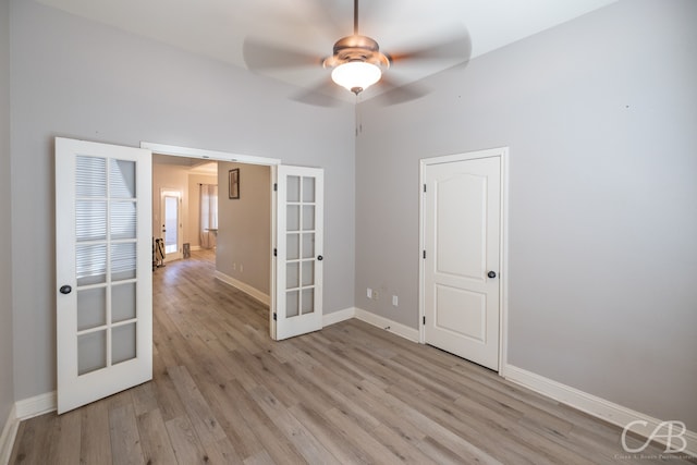 empty room featuring light wood-type flooring, ceiling fan, and french doors