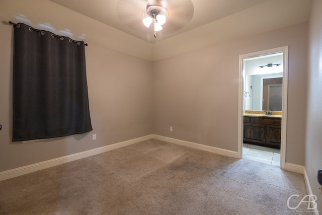 empty room with ceiling fan, light colored carpet, and sink