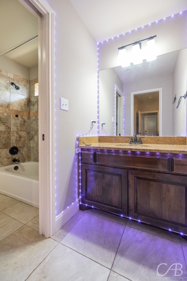 bathroom with vanity, tiled shower / bath combo, and tile patterned flooring