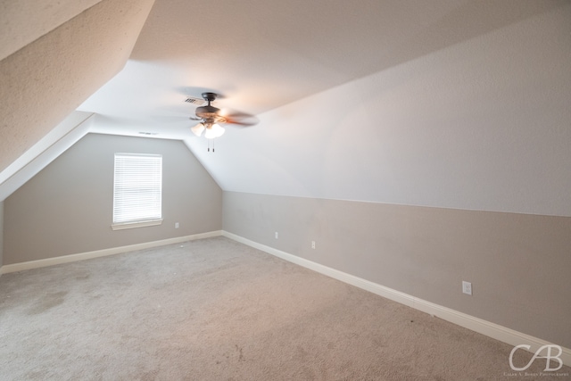 additional living space with ceiling fan, lofted ceiling, and carpet flooring