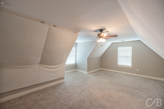 additional living space featuring a wealth of natural light, carpet, ceiling fan, and vaulted ceiling