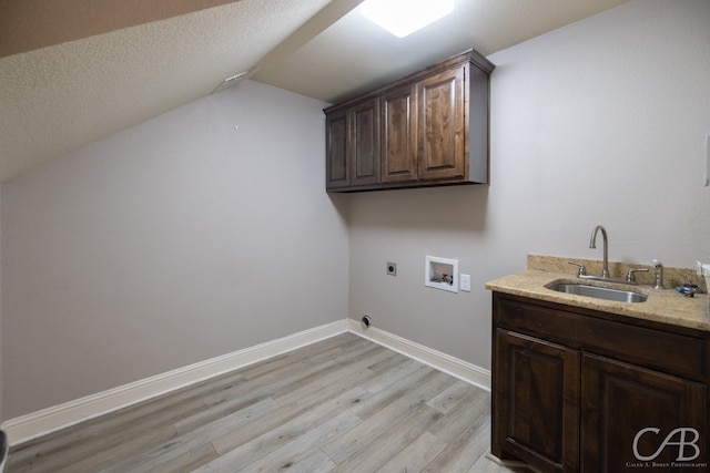 laundry area featuring hookup for a washing machine, light wood-type flooring, electric dryer hookup, cabinets, and sink