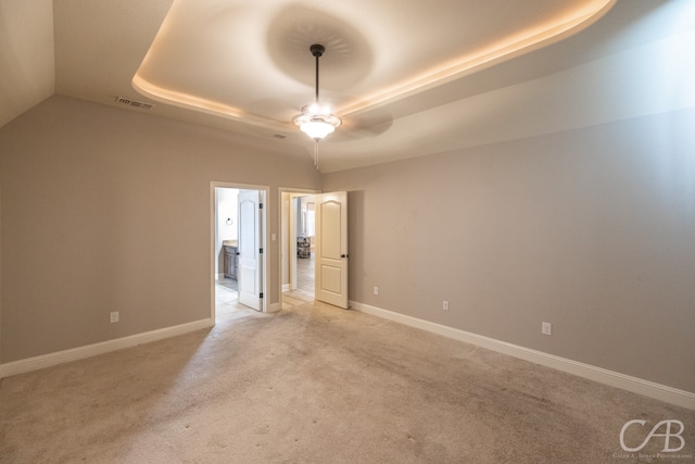 carpeted empty room featuring a tray ceiling and ceiling fan