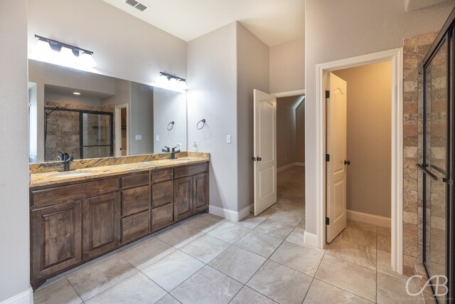 bathroom featuring vanity, a shower with door, and tile patterned floors