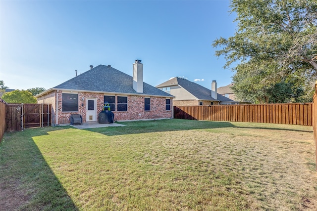 rear view of house with a lawn and a patio area