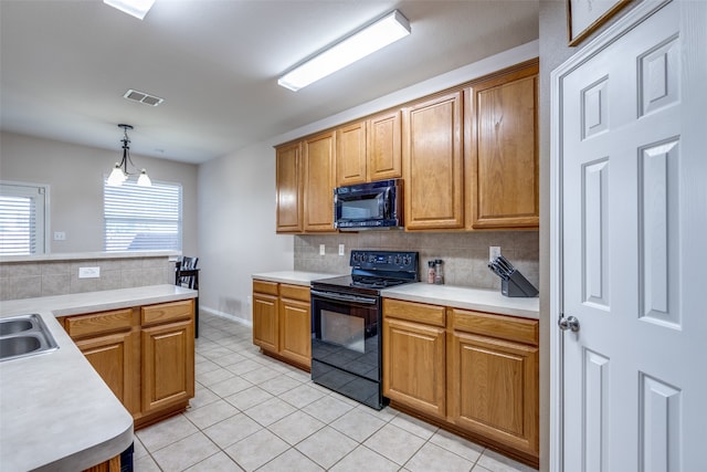 kitchen with light tile patterned flooring, hanging light fixtures, tasteful backsplash, and black appliances