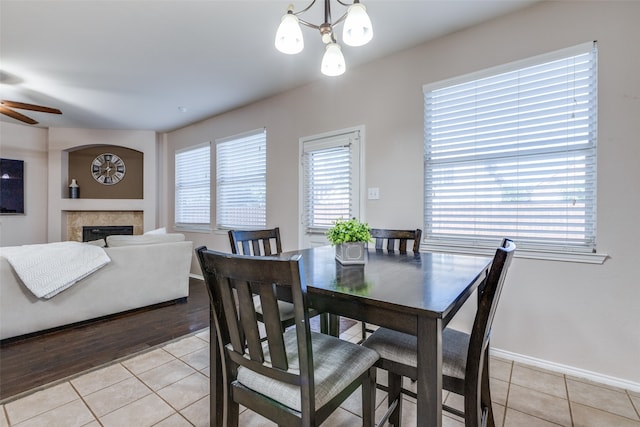 dining space with light wood-type flooring and ceiling fan with notable chandelier