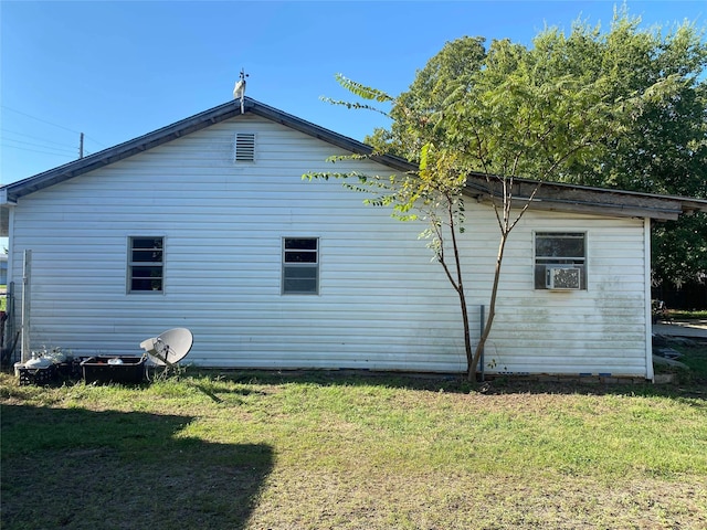 view of side of home featuring cooling unit and a yard