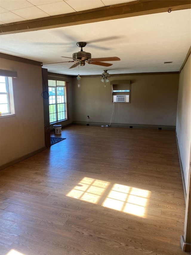 spare room with ceiling fan, hardwood / wood-style floors, and a healthy amount of sunlight