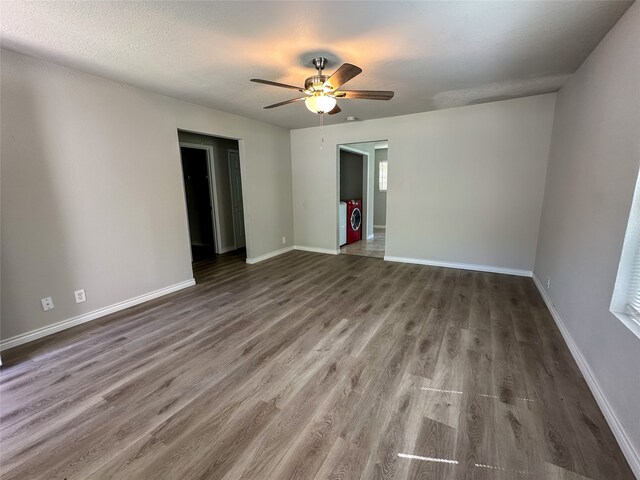 interior space featuring washing machine and clothes dryer, a textured ceiling, dark hardwood / wood-style floors, and ceiling fan