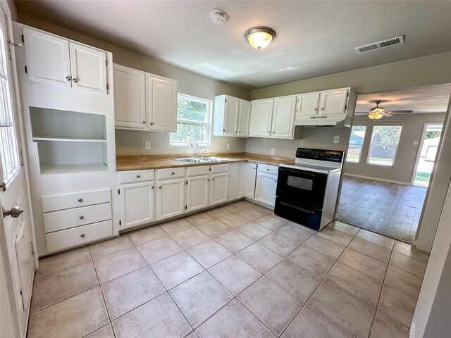 kitchen featuring ceiling fan, white range with electric cooktop, sink, and white cabinets