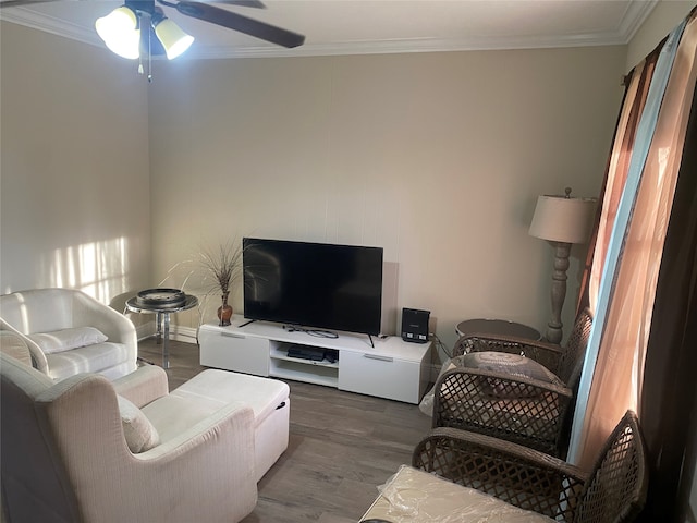 living room with ornamental molding, ceiling fan, and dark wood-type flooring