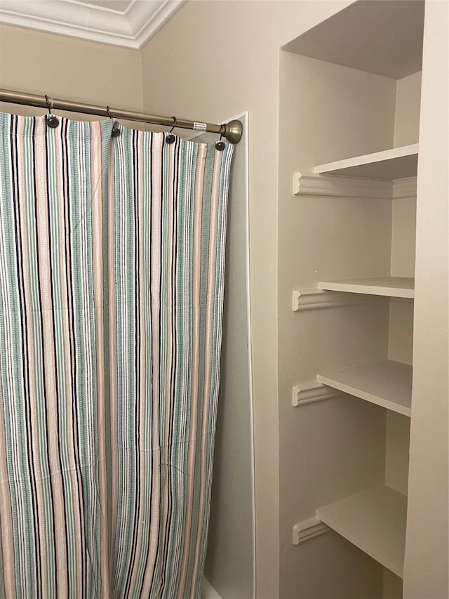 bathroom with ornamental molding and a shower with shower curtain