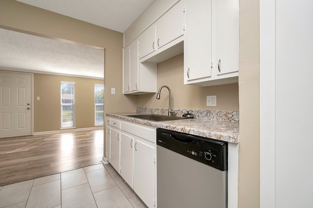 kitchen with white cabinets, dishwasher, light wood-type flooring, a textured ceiling, and sink