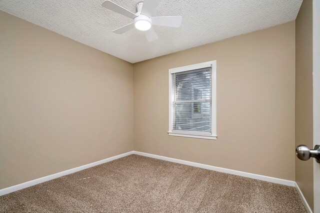 carpeted spare room featuring ceiling fan and a textured ceiling