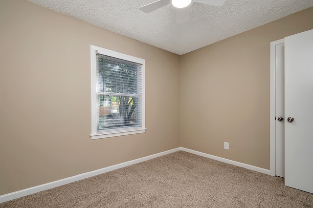 carpeted spare room with a textured ceiling and ceiling fan