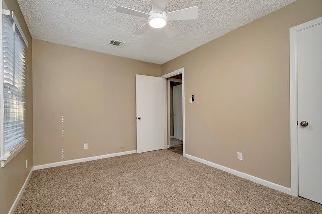 unfurnished bedroom featuring ceiling fan, carpet floors, and a textured ceiling