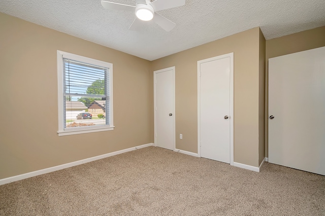 unfurnished bedroom with ceiling fan, a textured ceiling, and carpet