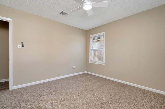 carpeted empty room with ceiling fan and a textured ceiling