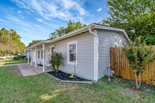 view of side of property with a lawn and a patio