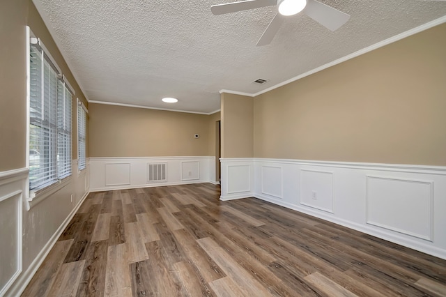 spare room with ceiling fan, a textured ceiling, ornamental molding, and wood-type flooring